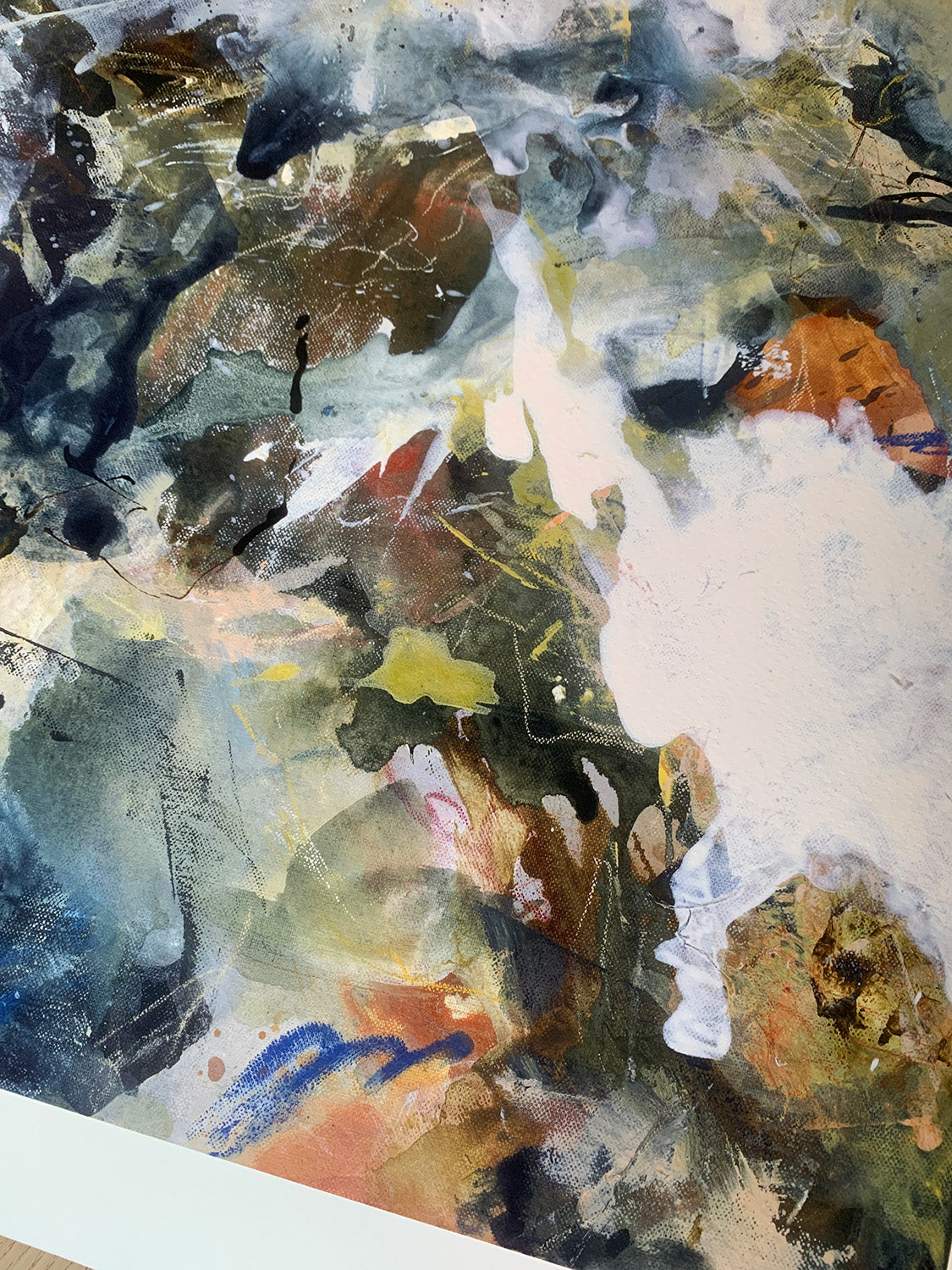 Close-up of abstract art print with a mix of white, brown, green and blue colours.
