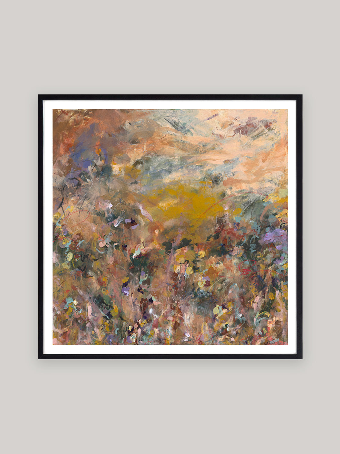 Abstract art print with warm colours in black frame on a neutral background.