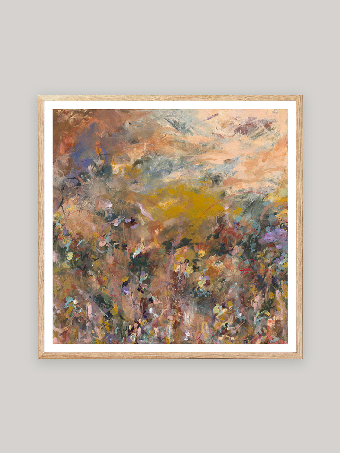 Abstract art print with warm colours in oak frame on a neutral background.
