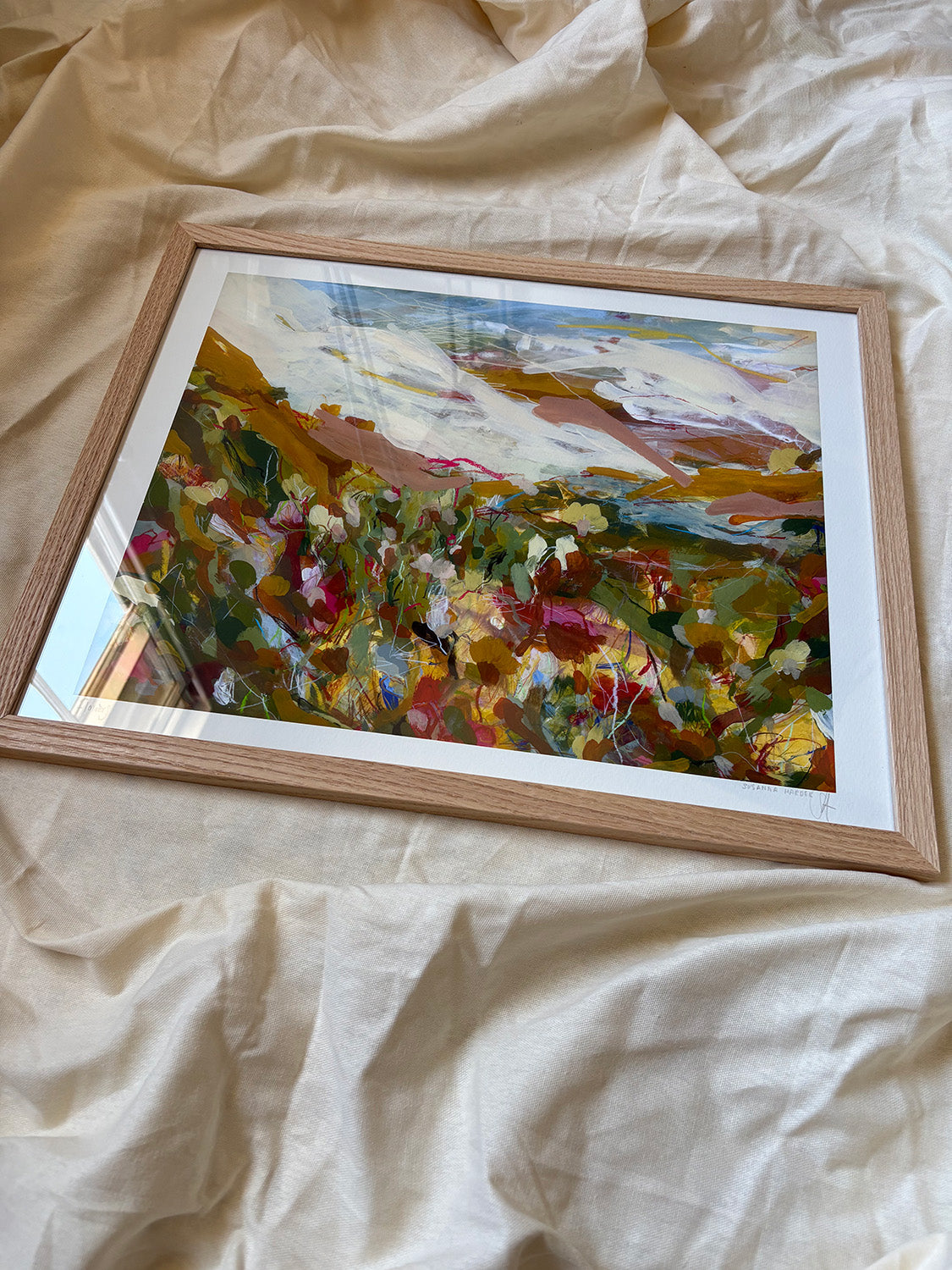 Framed abstract art print with vibrant colours on a textured surface.