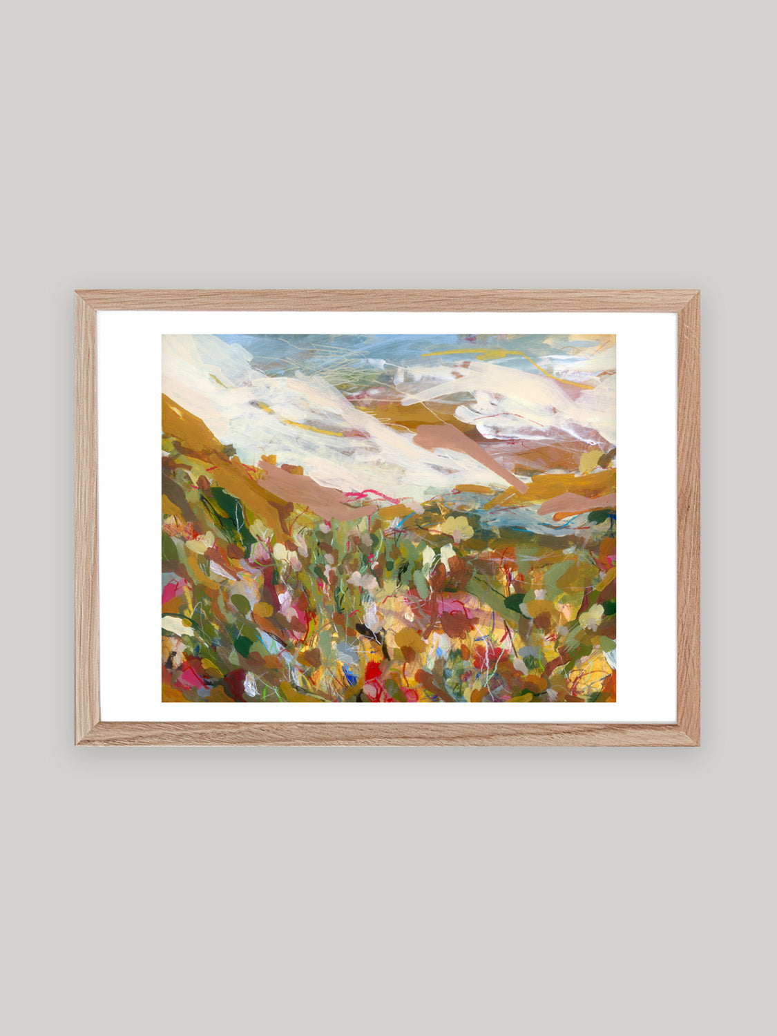 Abstract art print with vibrant colours in oak frame on a neutral background.