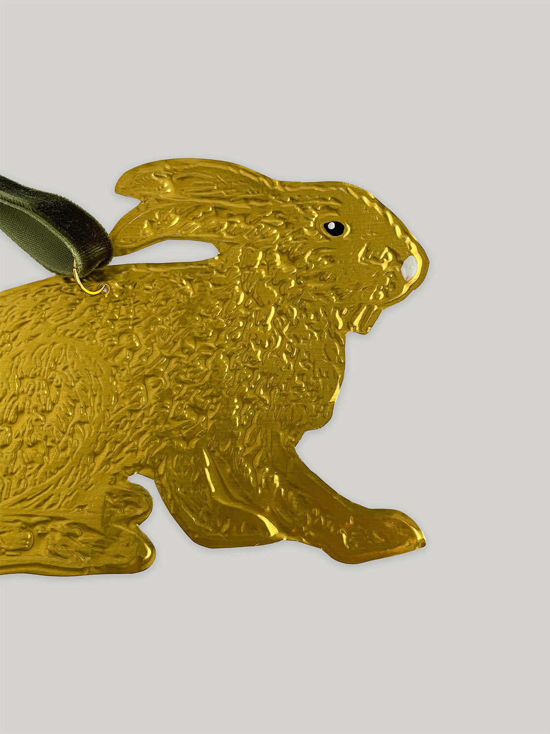 Gold tin hare handmade ornament with green velvet ribbon on a neutral background - close-up detail 2.