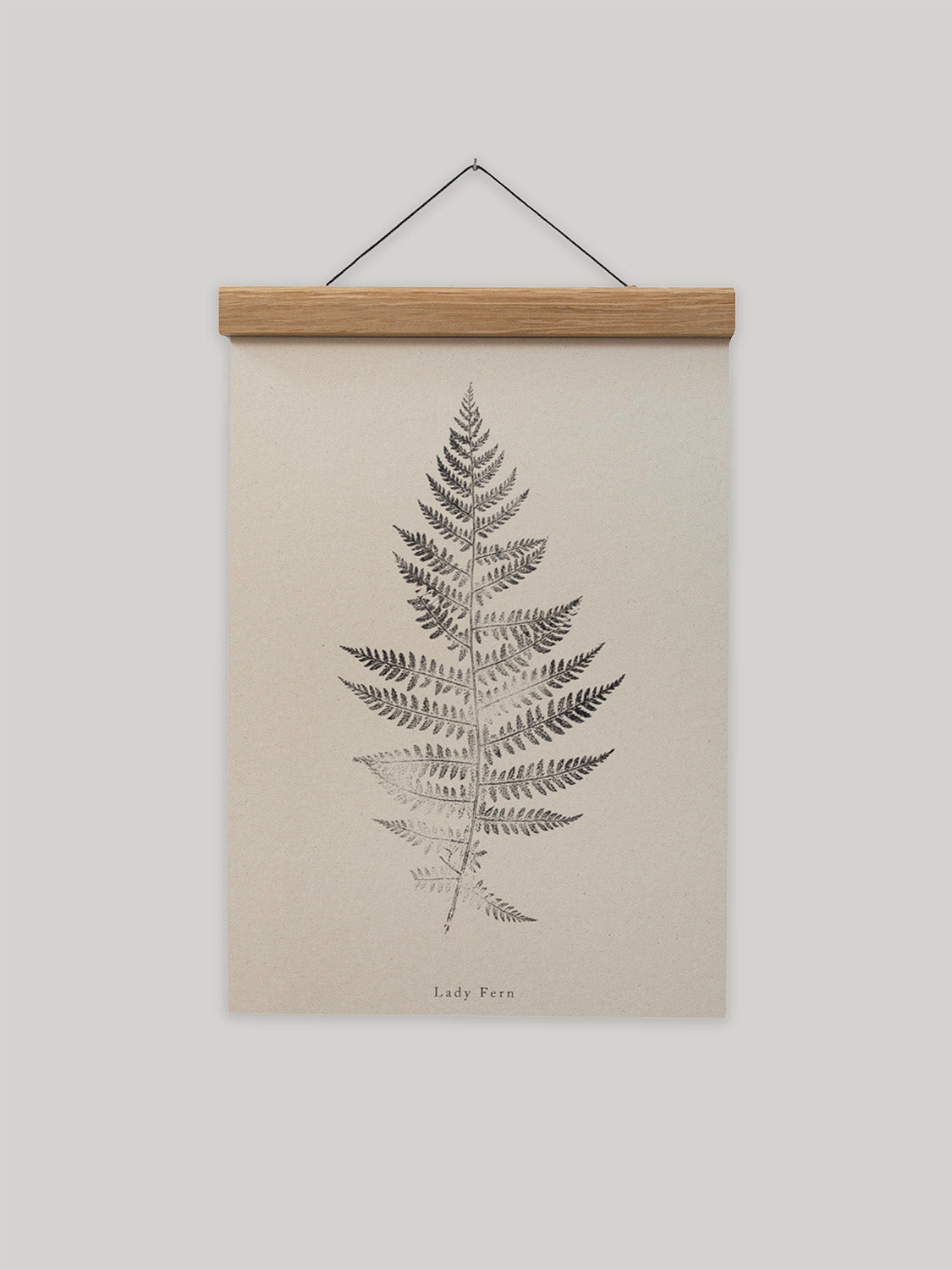 Framed print of a fern leaf on a beige background.