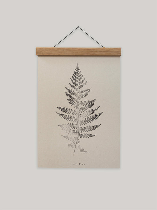 Framed print of a fern leaf on a beige background.