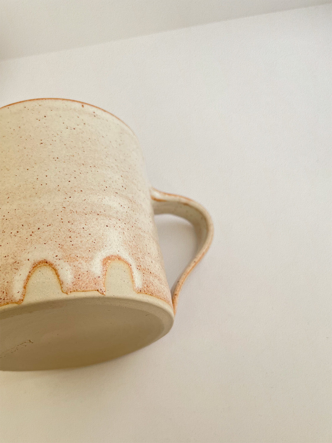 Close-up of rust ceramic mug on a neutral background.