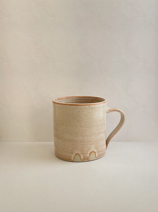 Rust ceramic mug on a neutral background - left side view.