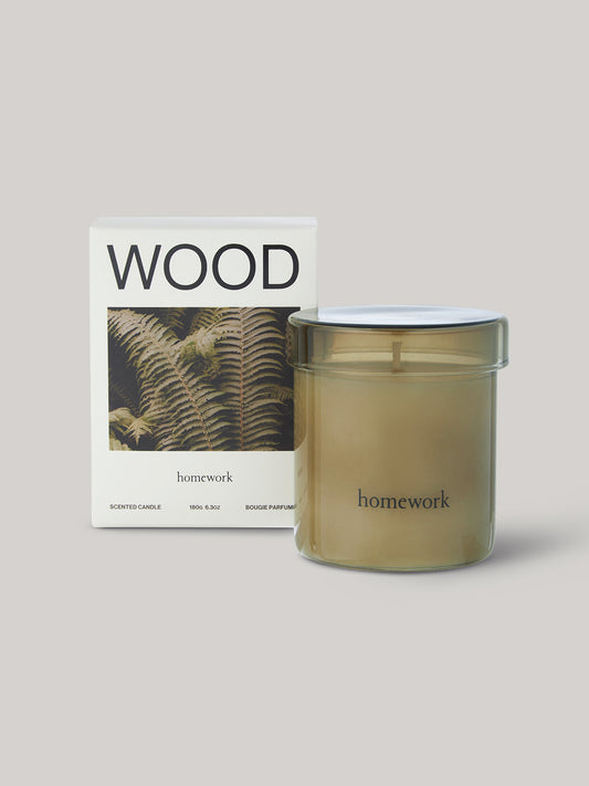 Candle in smoked glass jar labelled 'homework' with packaging featuring the word 'WOOD'.