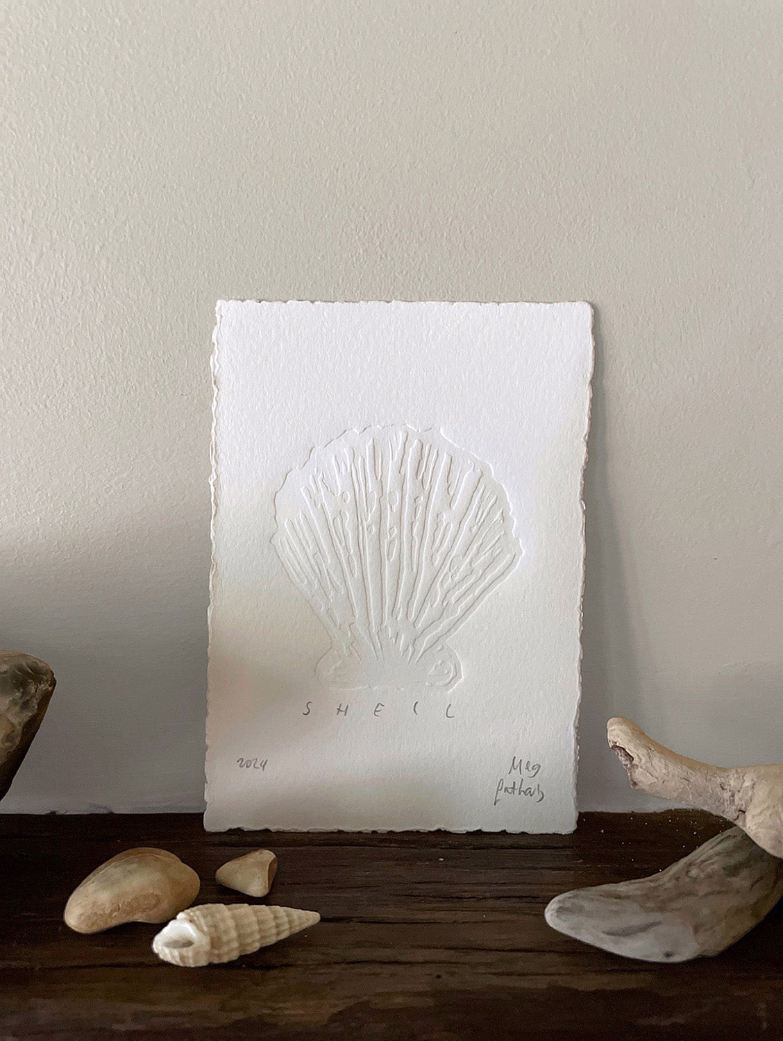 Shell hand-embossed artwork with shells and driftwood.