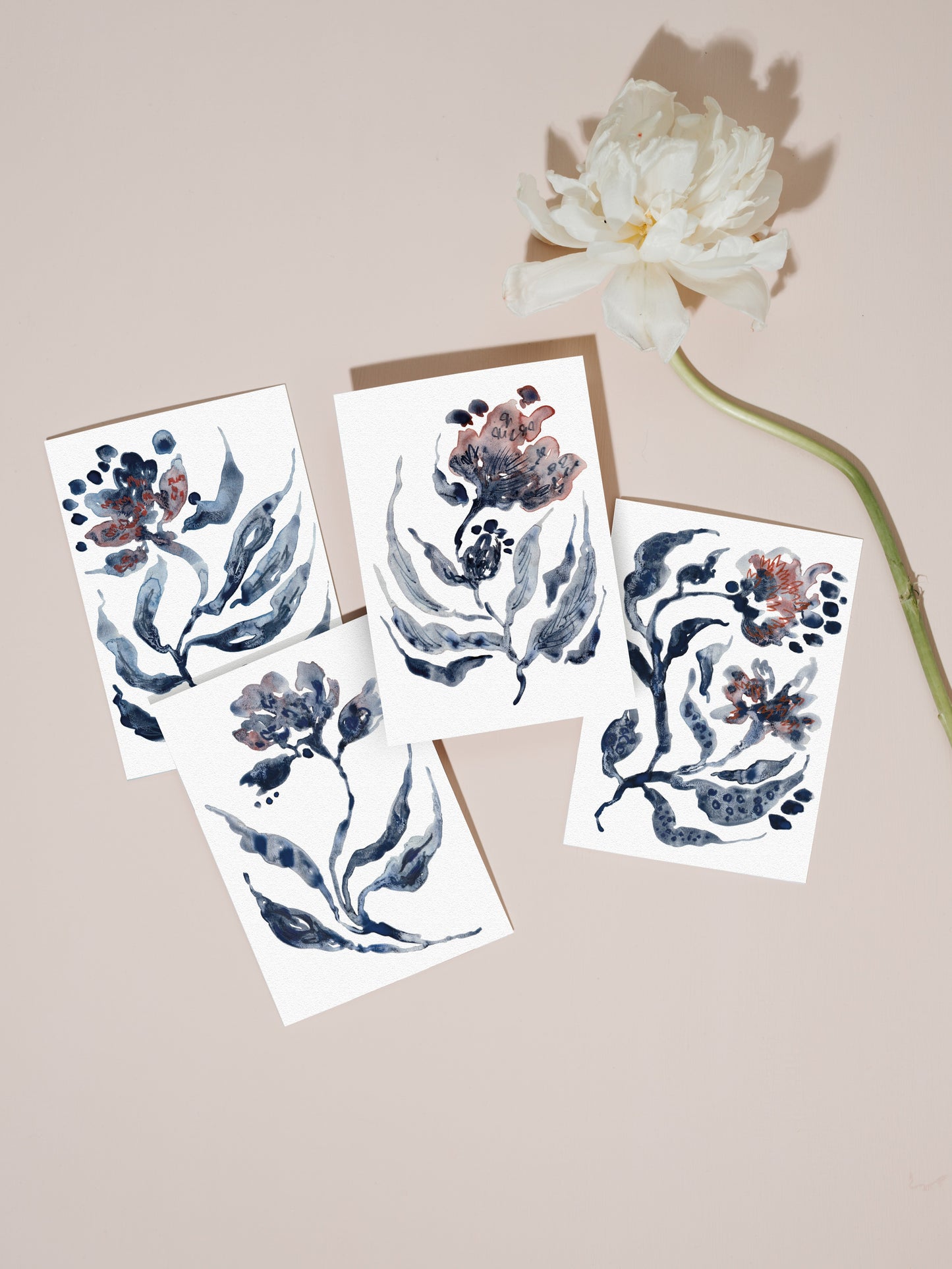 Set of floral greetings cards with a white flower on a pale pink background.