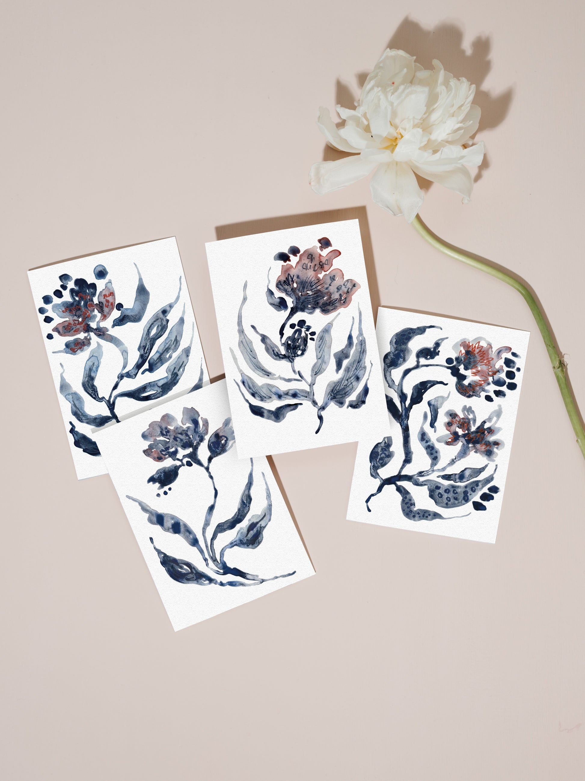 Set of floral greetings cards with a white flower on a pale pink background.