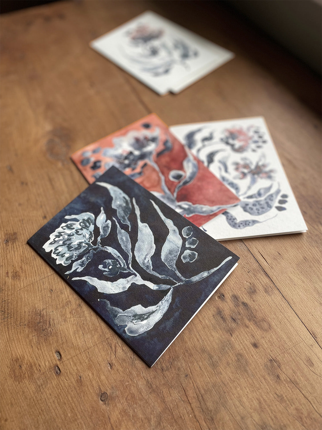 Floral greetings cards on a wooden surface.