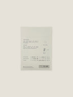 Back of Ammi Majus seed packet with text and growing instructions on a neutral background.
