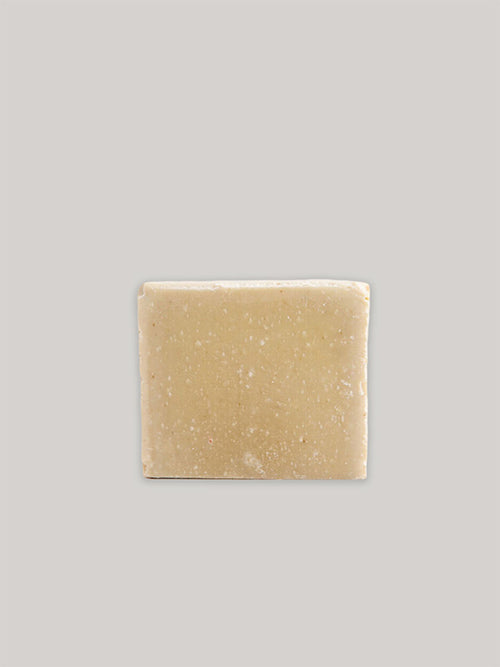 Cedarwood and Green Clay handmade soap on plain taupe background.