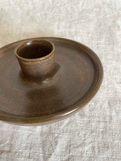 Low round ceramic candle holder in brown glaze - close-up.