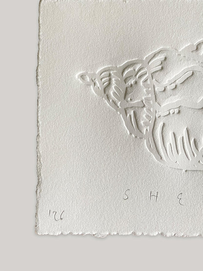 Conch shell hand-embossed artwork on white paper with 'Shell' text and deckled edges - close-up detail 1.