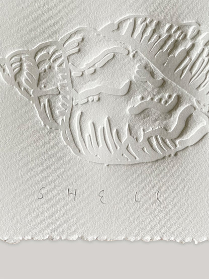 Conch shell hand-embossed artwork on white paper with 'Shell' text and deckled edges - close-up detail 2.