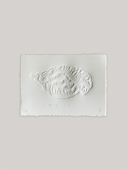 Conch shell hand-embossed artwork on white paper with 'Shell' text and deckled edges.