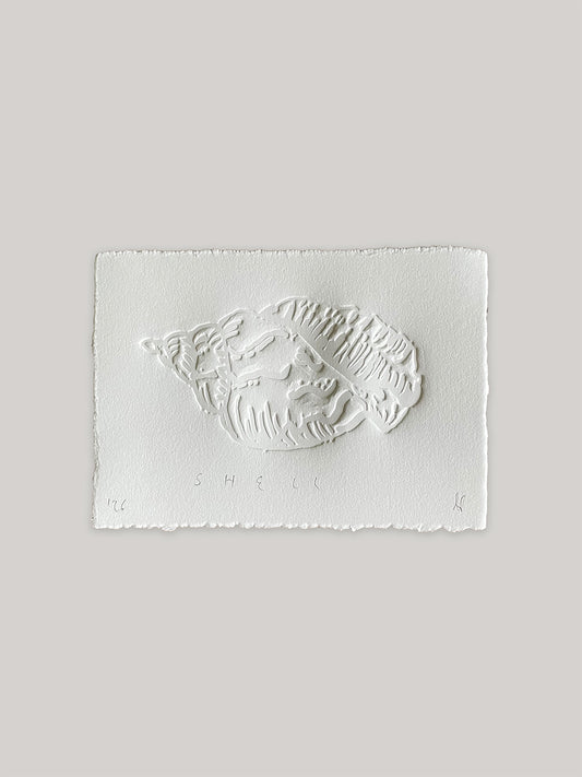 Conch shell hand-embossed artwork on white paper with 'Shell' text and deckled edges.