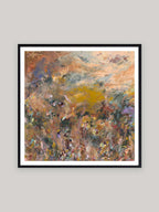 Abstract art print with warm colours in black frame on a neutral background.