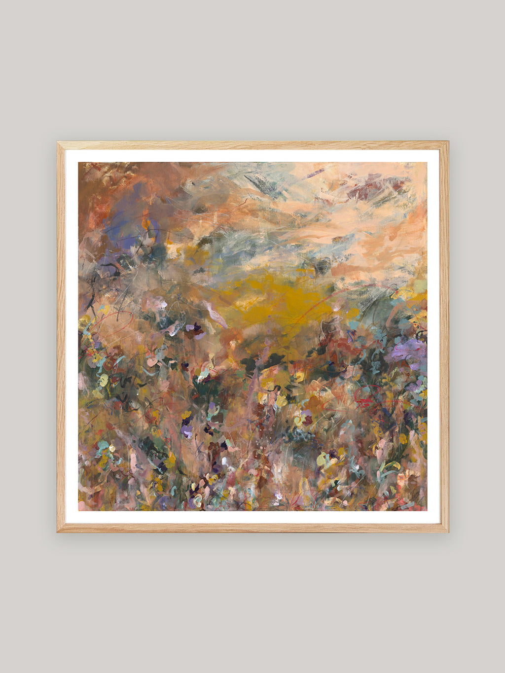 Abstract art print with warm colours in oak frame on a neutral background.