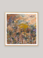 Abstract art print with warm colours in oak frame on a neutral background.