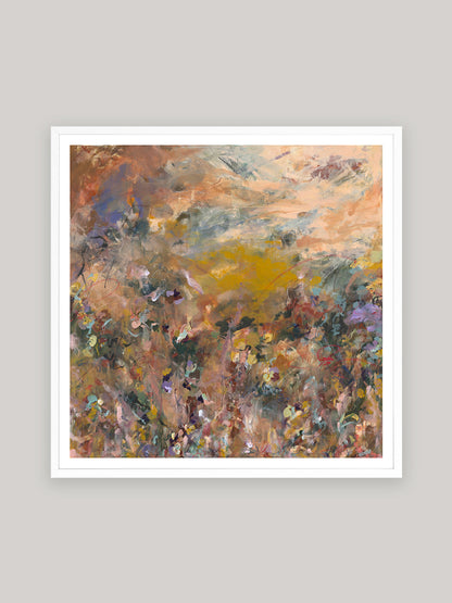 Abstract art print with warm colours in white frame on a neutral background.