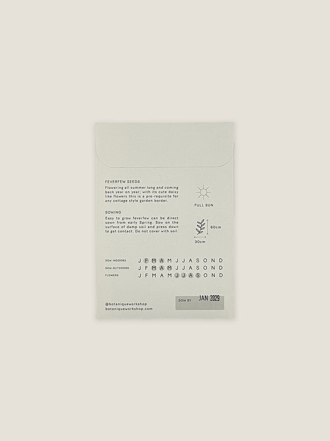 Back of Feverfew seed packet with text and growing instructions on a neutral background.