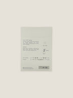 Back of Field Poppy seed packet with text and growing instructions on a neutral background.