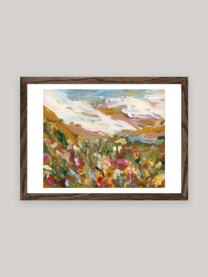 Abstract art print with vibrant colours in dark oak frame on a neutral background.