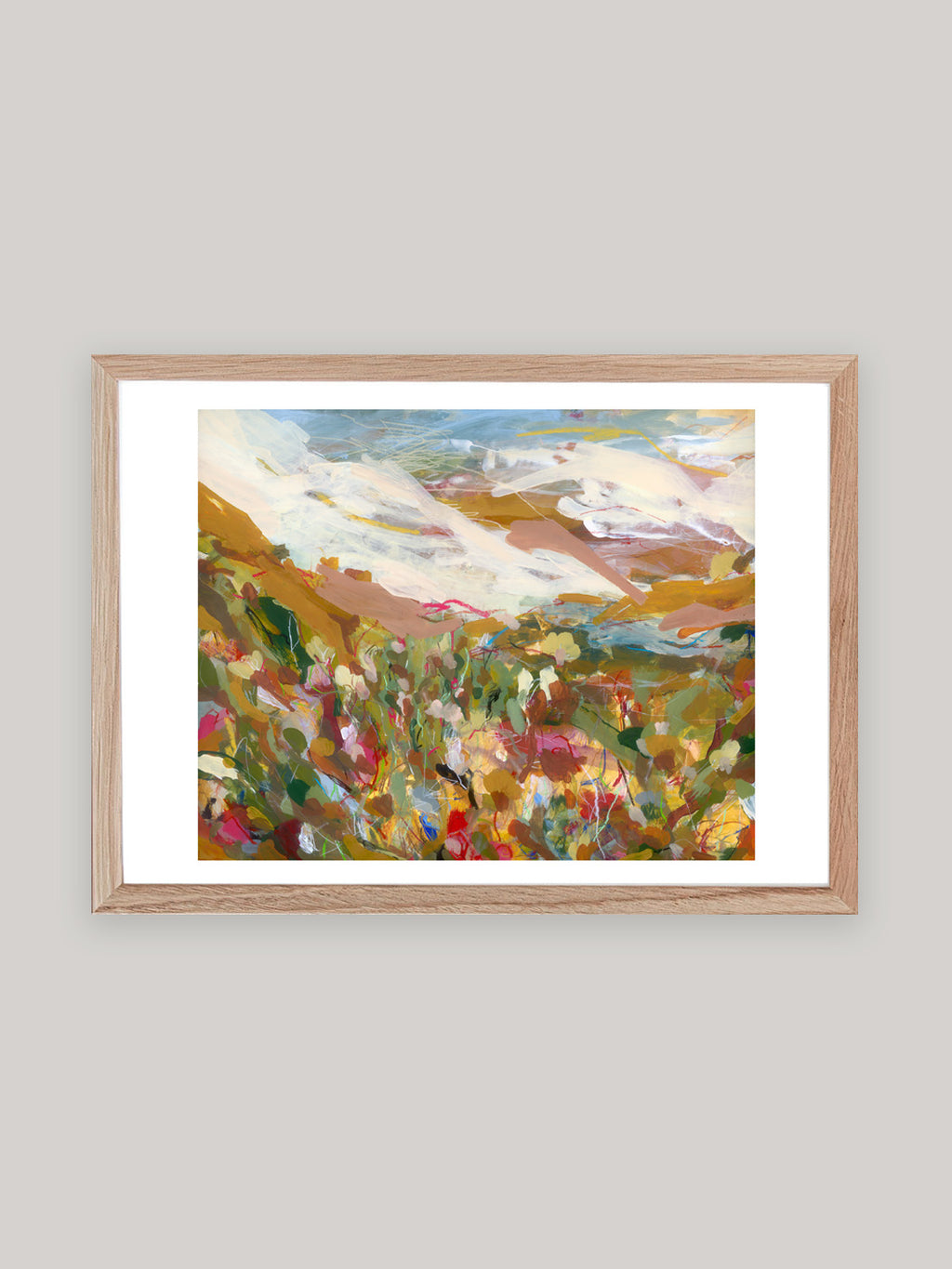 Abstract art print with vibrant colours in oak frame on a neutral background.