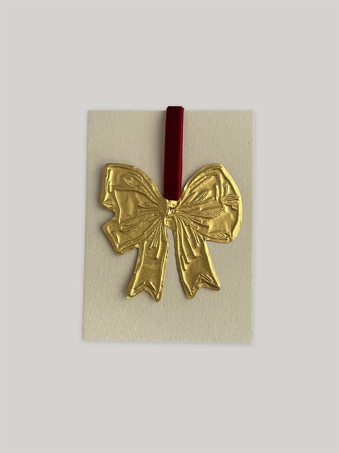 Gold tin bow handmade Christmas decoration with red velvet ribbon with packaging.