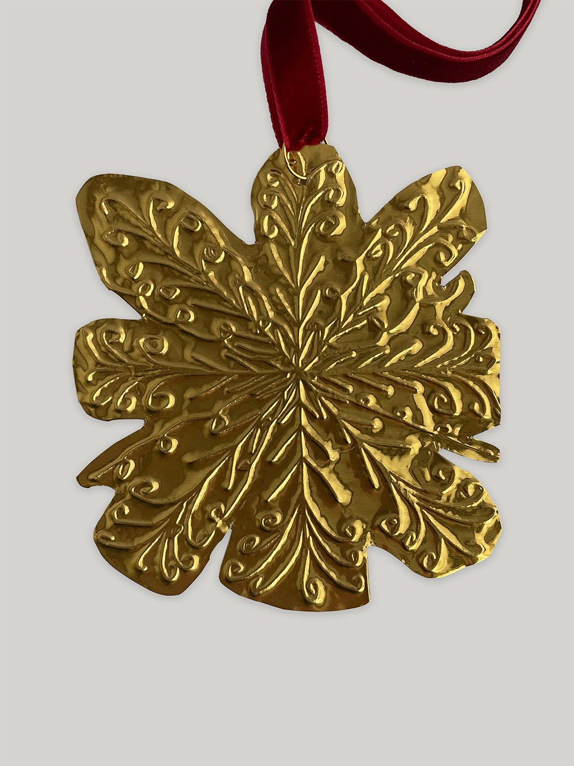 Gold tin snowflake handmade Christmas decoration with red velvet ribbon - detail.