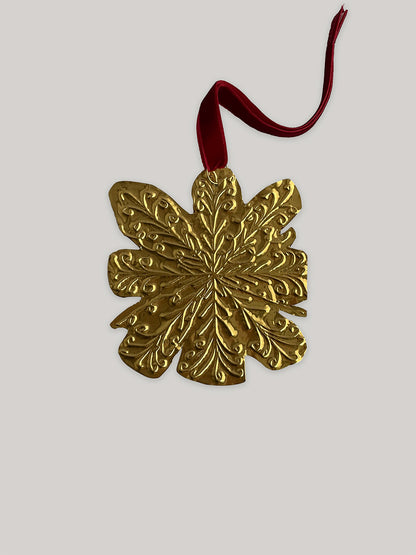 Gold tin snowflake handmade Christmas decoration with red velvet ribbon - front.