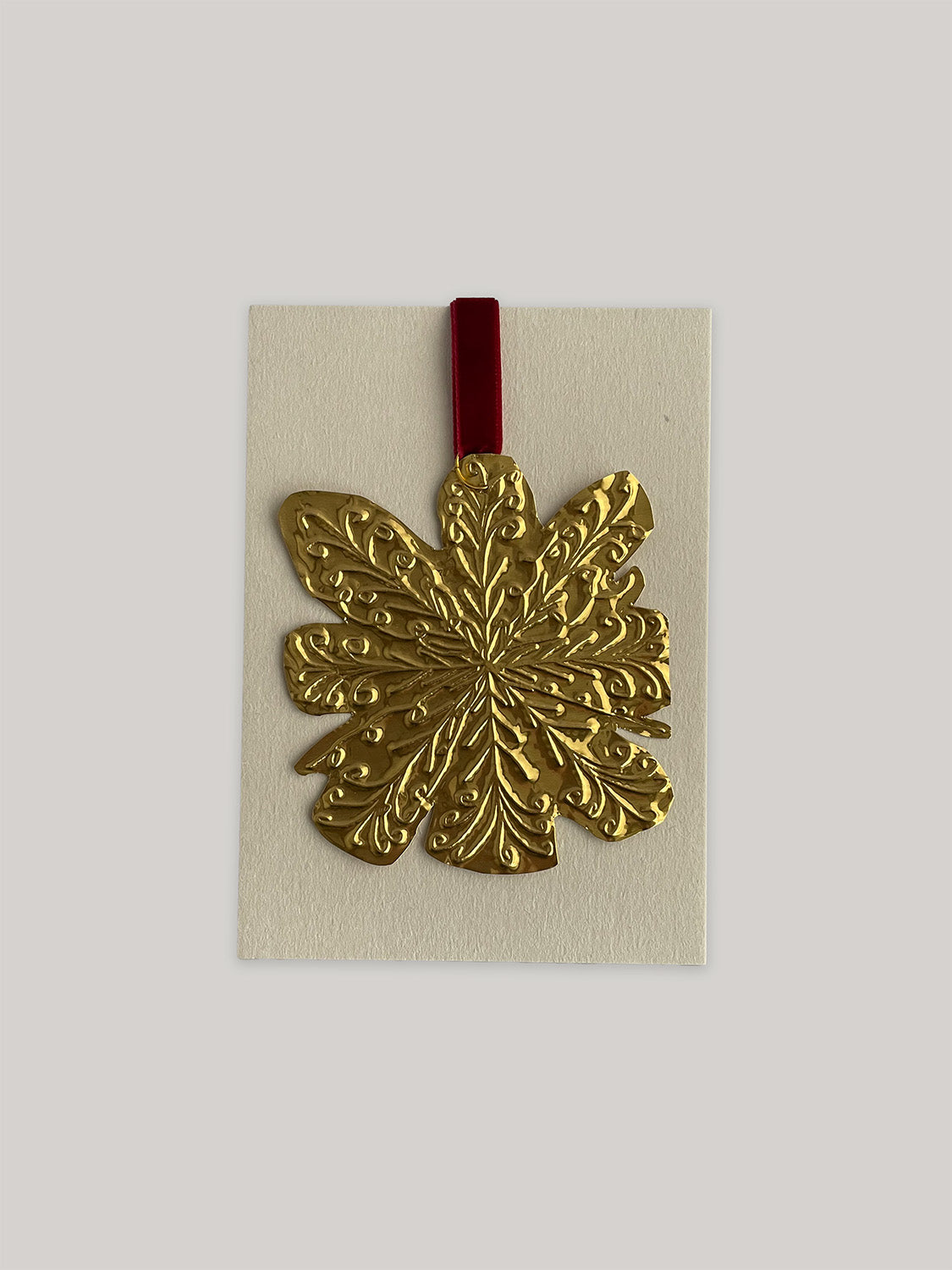 Gold tin snowflake handmade Christmas decoration with red velvet ribbon with packaging.