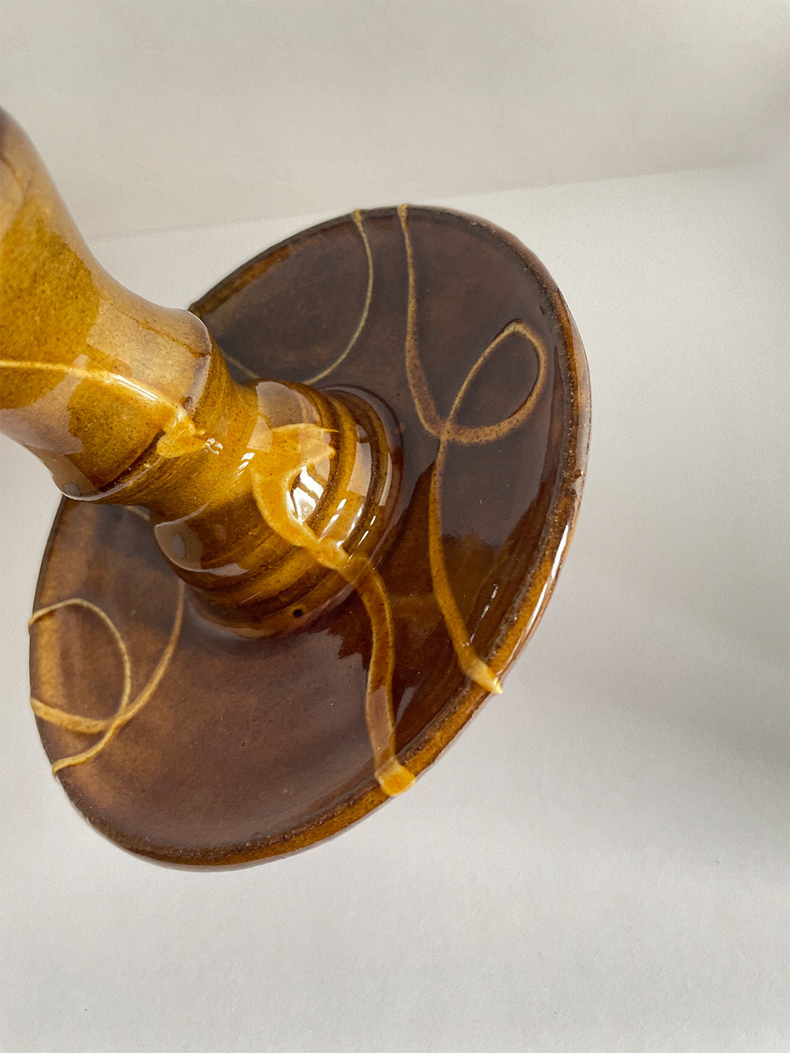 Close-up view of brown and gold handmade ceramic candle holder with decorative patterns.