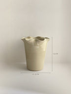 A handmade ceramic cream coloured vase with a frilled, wavy rim and dimensions shown, on a neutral background.