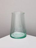 Handmade recycled glass tapered vase on a white surface with a neutral background.