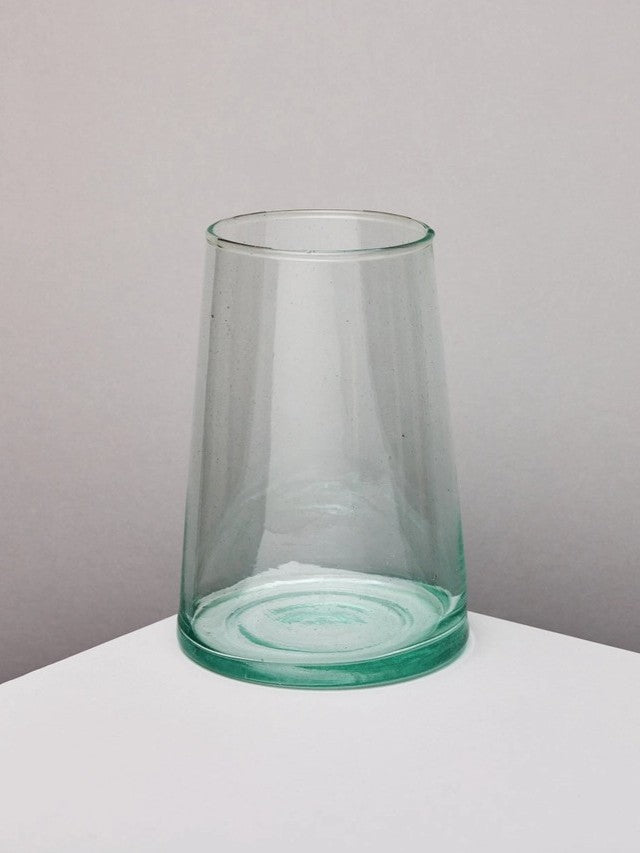 Handmade recycled glass tapered vase on a white surface with a neutral background.
