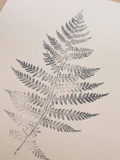 Close-up of fern leaf print on a beige background.
