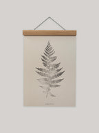 Framed print of a fern leaf on a beige background.
