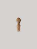 Oak wine bottle stopper on a neutral background.