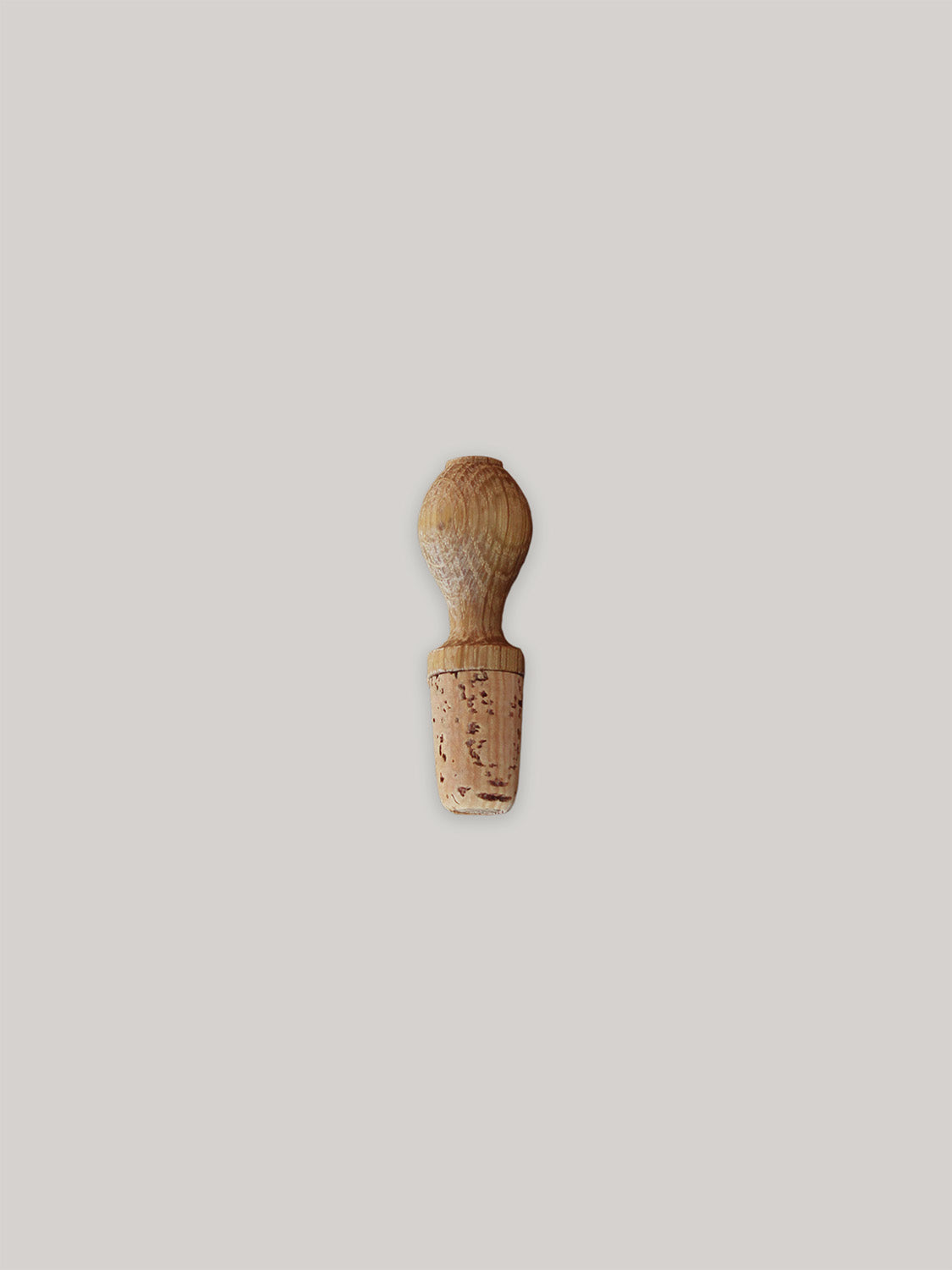 Oak wine bottle stopper on a neutral background.