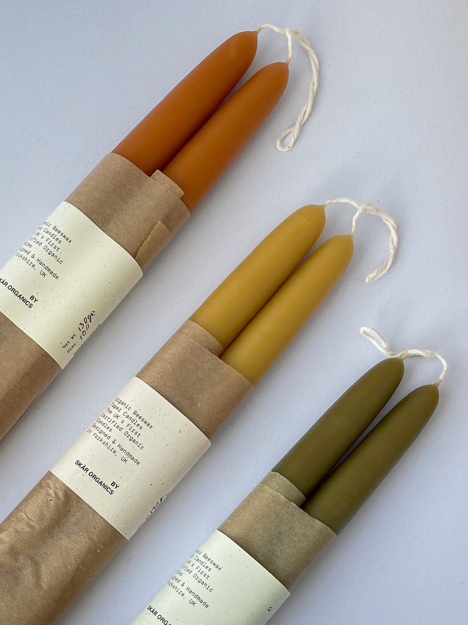 Group of three pairs of organic beeswax hand-dipped taper candles - top.