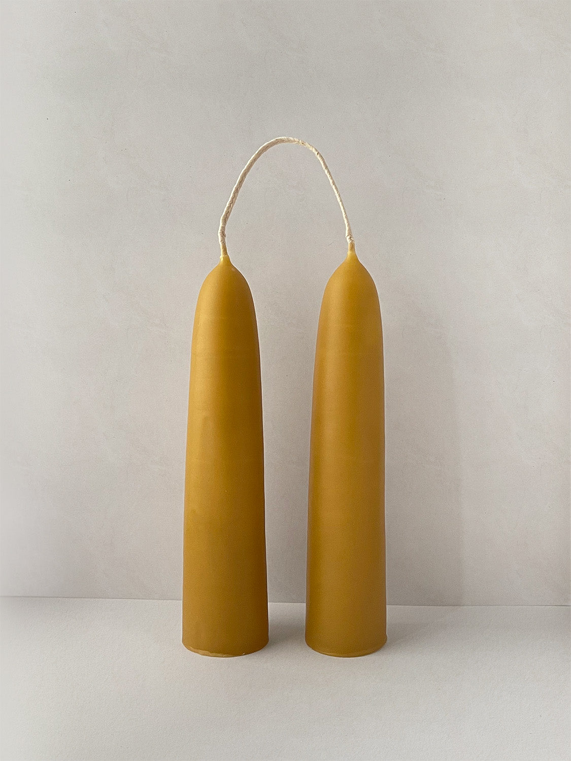 Pair of organic beeswax hand-dipped stubby candles - front.