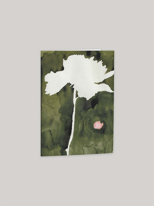 Greeting card with a white flower silhouette on a green watercolour background, on a neutral background.