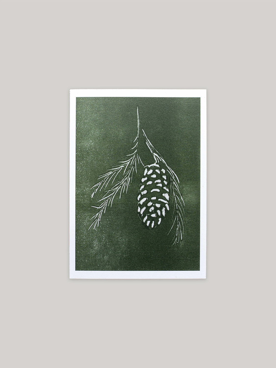 Botanical Christmas card with pine cone and branch design on a green background.