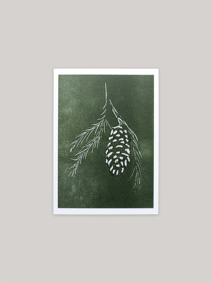 Botanical Christmas card with pine cone and branch design on a green background.