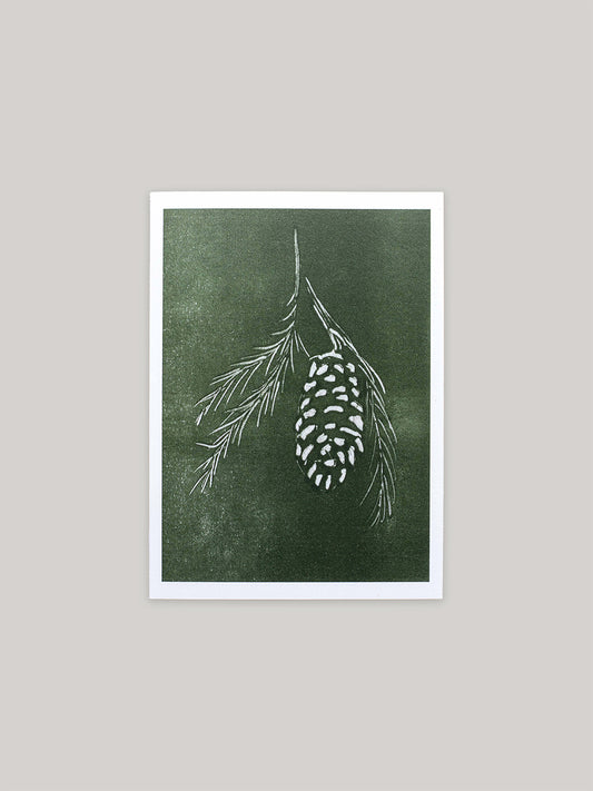 Botanical Christmas card with pine cone and branch design on a green background.