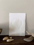 Shell hand-embossed artwork with shells and driftwood.