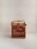 Box of hot chocolate with a red label on a neutral background.